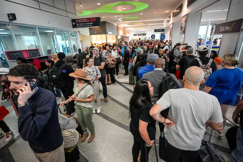 Crowded airport terminal during travel chaos caused by Middle East conflict disruptions.