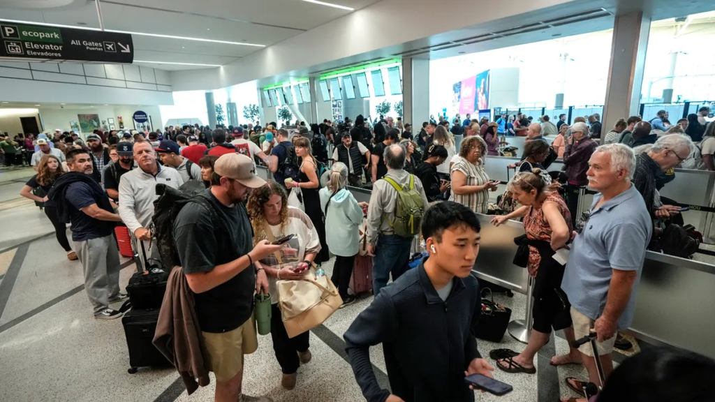 Crowded airport terminal during travel chaos caused by Middle East conflict disruptions.