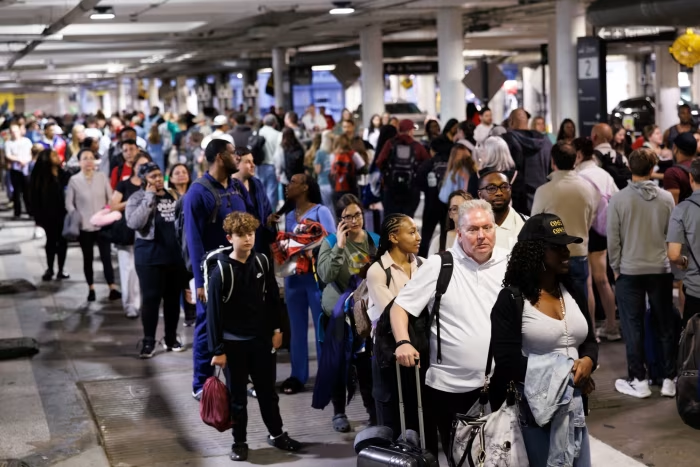 Crowded airport terminal during travel chaos caused by Middle East conflict disruptions.