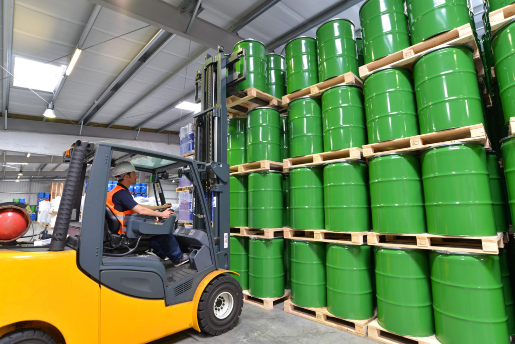 group of workers in the logistics industry work in a warehouse with chemicals - lifting truck