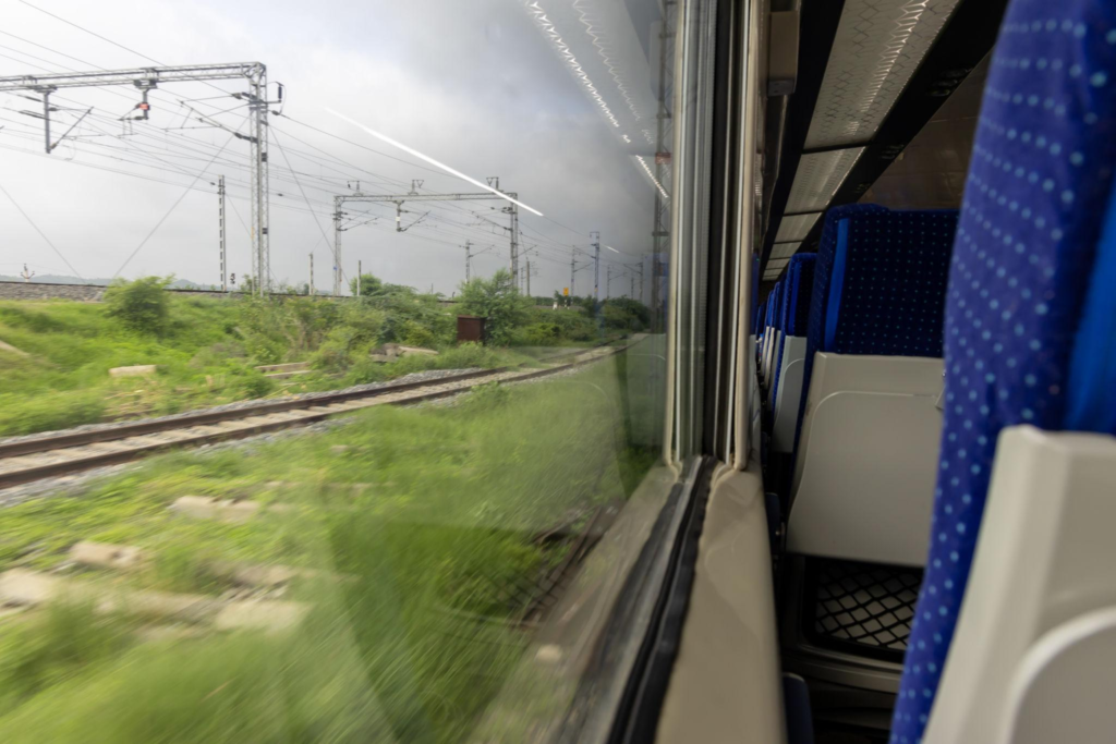 Vande Bharat High Speed Passenger Train Window View in Motion During Daytime