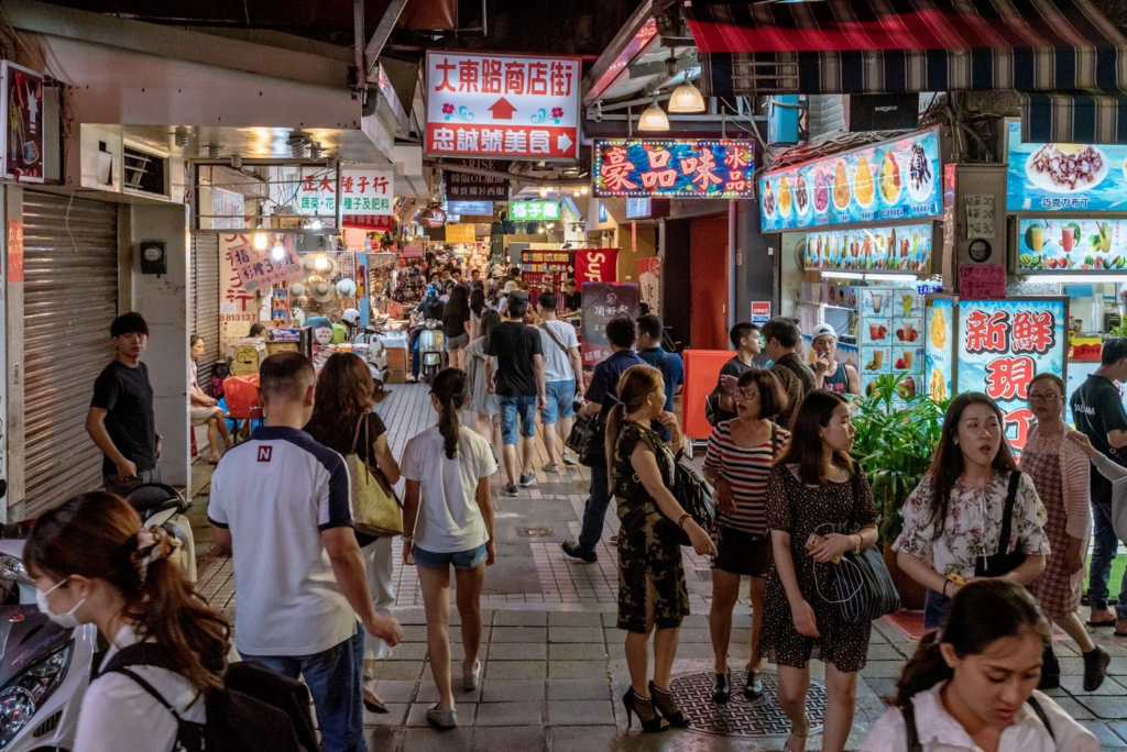 Busy Taipei night market in Taiwan with street food stalls and travelers during evening hours