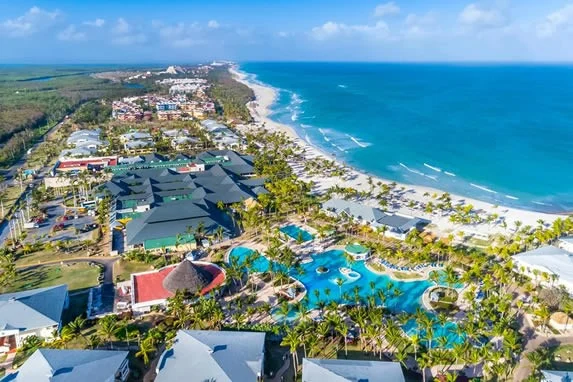 Aerial view of a large beach resort in Varadero, Cuba, with swimming pools, palm trees, and a white sand coastline