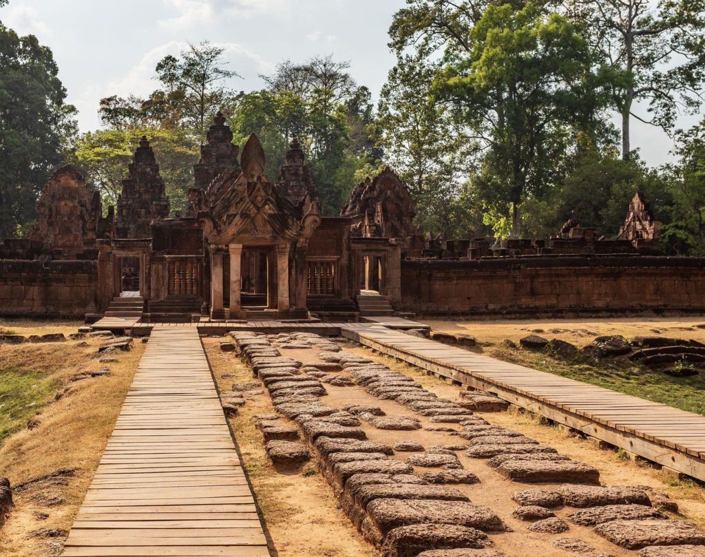 Ornate stone temple gateway in Siem Reap with wooden walkways leading through the ancient complex