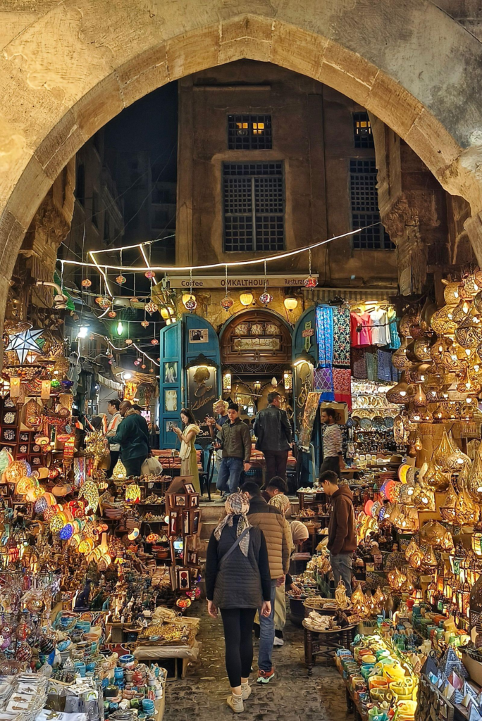 A bustling market in Historic Cairo at night, filled with glowing traditional lanterns and people walking