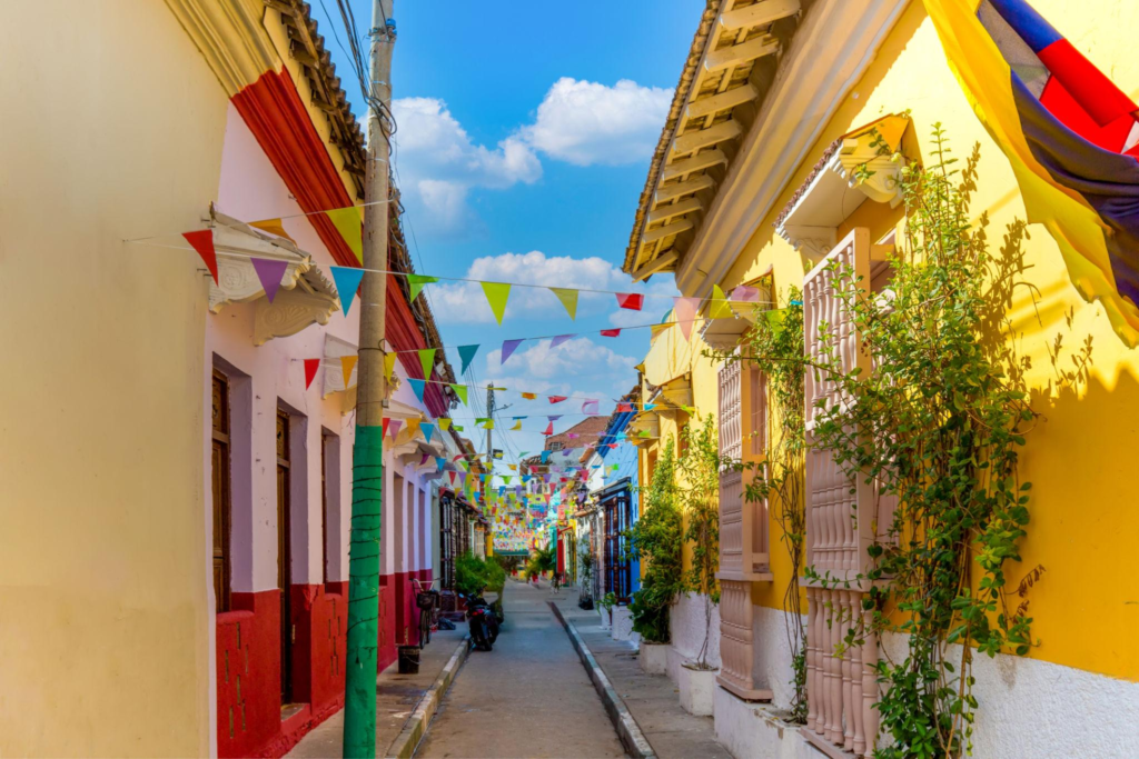 Brightly painted colonial buildings and colorful banners lining a narrow street in Cartagena, Colombia