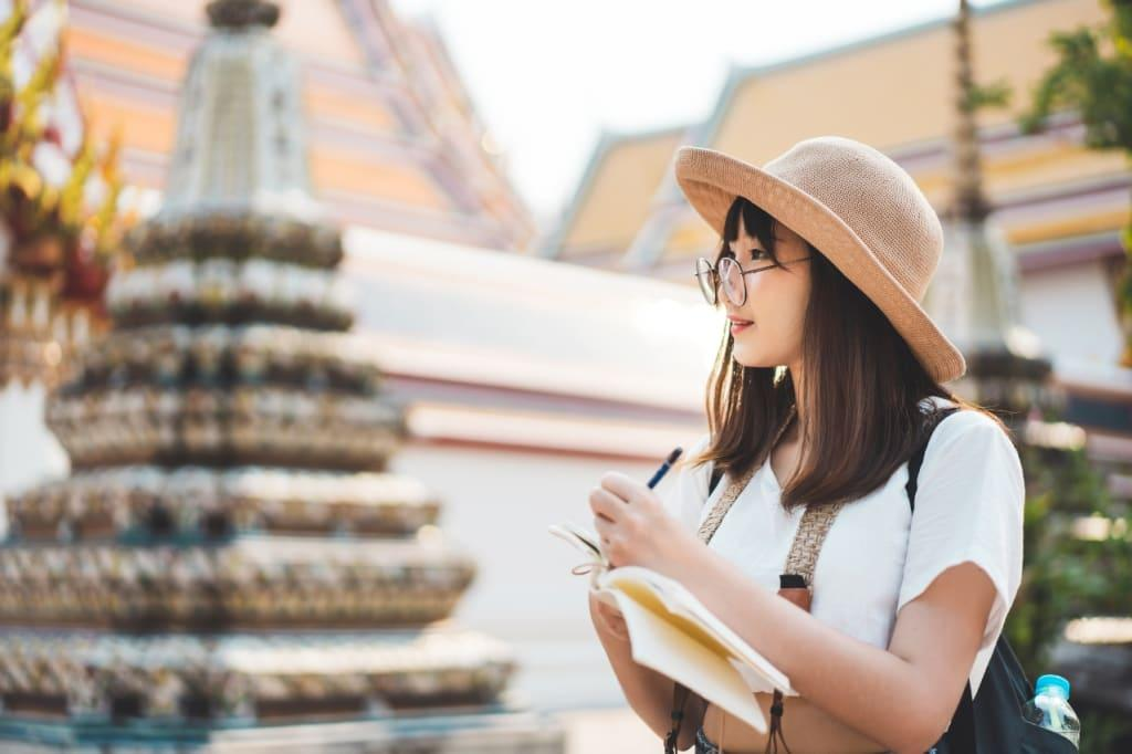 Solo traveler taking notes while observing traditional temple architecture