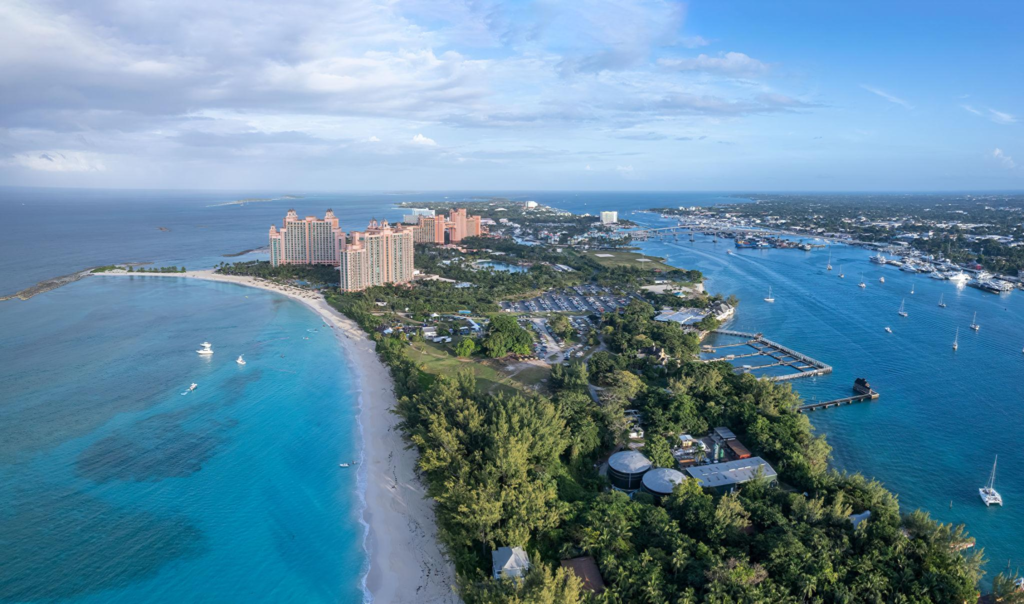 Aerial view of Paradise Island, Bahamas, showing large pink resorts along a white sand beach and turquoise water