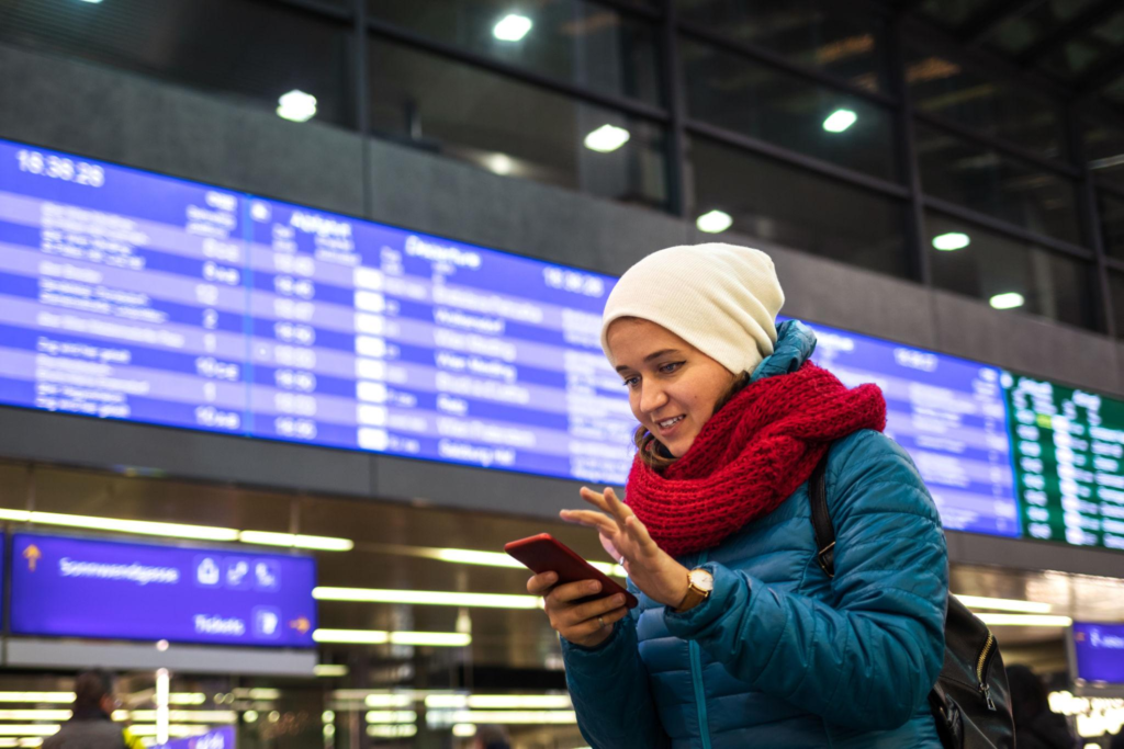 Young woman is booking railway ticket by using mobile app on her smartphone